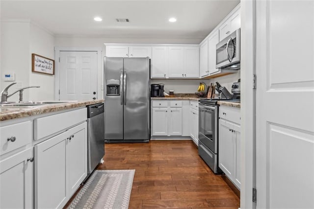 1081 Oak Hill Ln, Madison, GA 30650 - kitchen with stainless steel appliances, a sink, white cabinetry, dark wood finished floors, and crown molding
