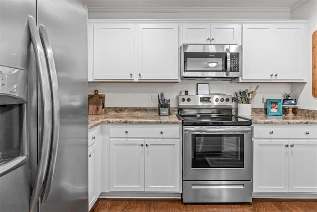 1081 Oak Hill Ln, Madison, GA 30650 - kitchen featuring appliances with stainless steel finishes, white cabinets, ornamental molding, and dark wood finished floors