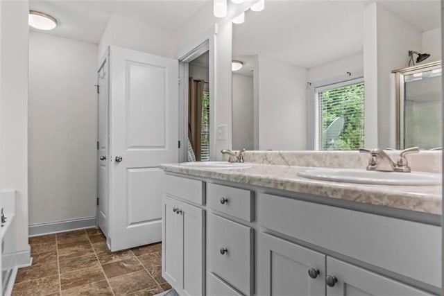 1081 Oak Hill Ln, Madison, GA 30650 - bathroom featuring double vanity, baseboards, a tub to relax in, and stone finish flooring