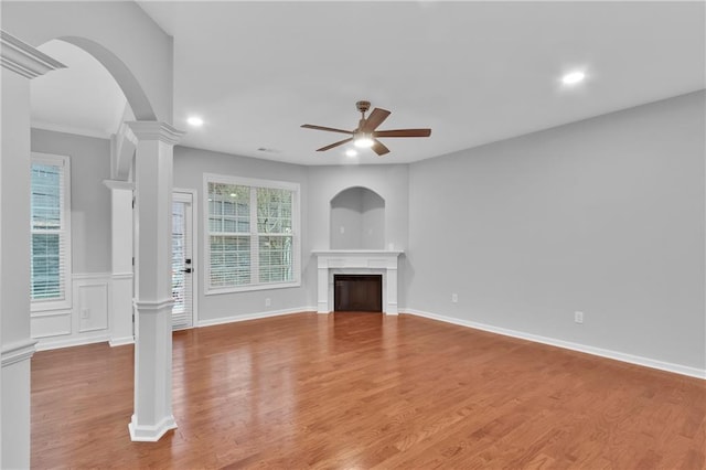 unfurnished living room with a fireplace, recessed lighting, a ceiling fan, light wood-type flooring, and ornate columns