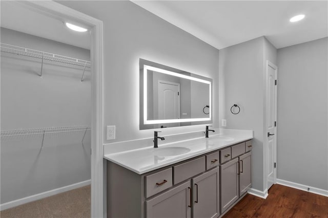 bathroom featuring double vanity, baseboards, and a sink