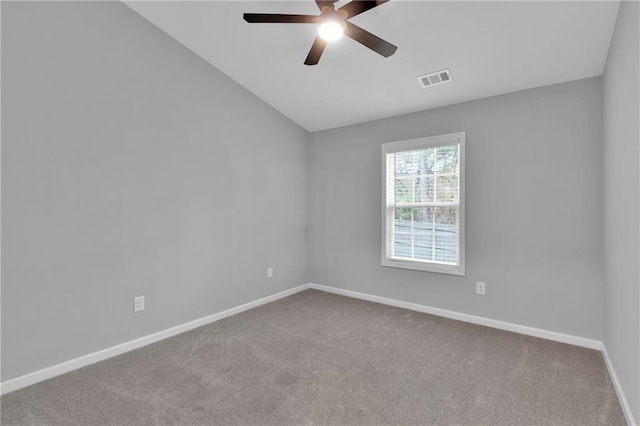 unfurnished room with lofted ceiling, light colored carpet, visible vents, a ceiling fan, and baseboards