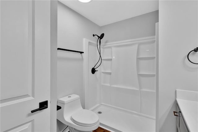 bathroom featuring vanity, a shower stall, and toilet