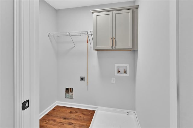 washroom with washer hookup, wood finished floors, baseboards, cabinet space, and electric dryer hookup