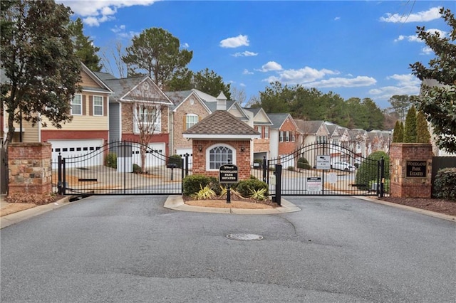 view of street featuring a residential view, curbs, and a gated entry