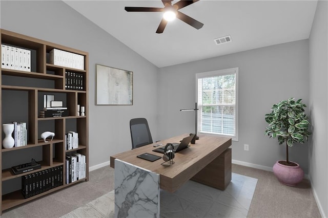 office space featuring baseboards, visible vents, vaulted ceiling, and light colored carpet