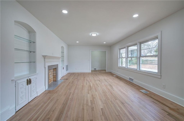 unfurnished living room featuring light wood-type flooring and built in features