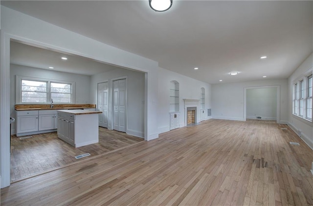 unfurnished living room featuring light hardwood / wood-style flooring and sink