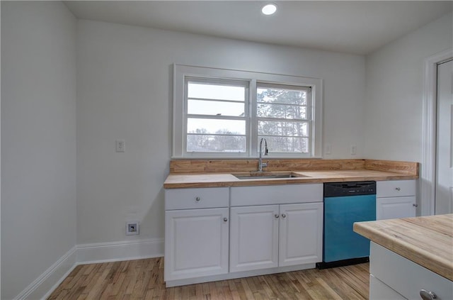 kitchen with butcher block counters, sink, stainless steel dishwasher, white cabinets, and light wood-type flooring