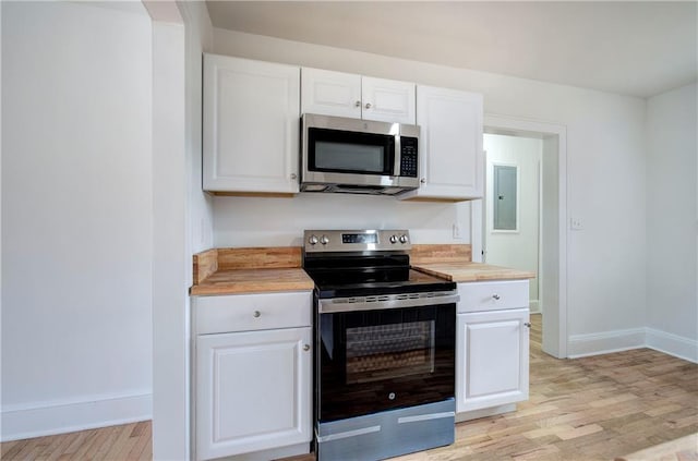 kitchen with white cabinetry, wooden counters, light hardwood / wood-style floors, and appliances with stainless steel finishes