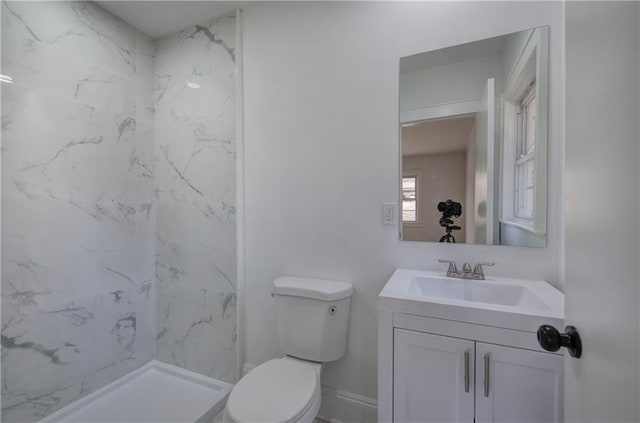 bathroom featuring a shower, vanity, and toilet