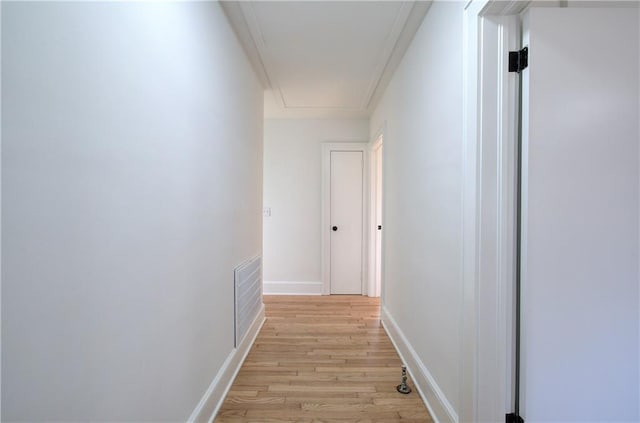 hallway featuring crown molding and light hardwood / wood-style floors