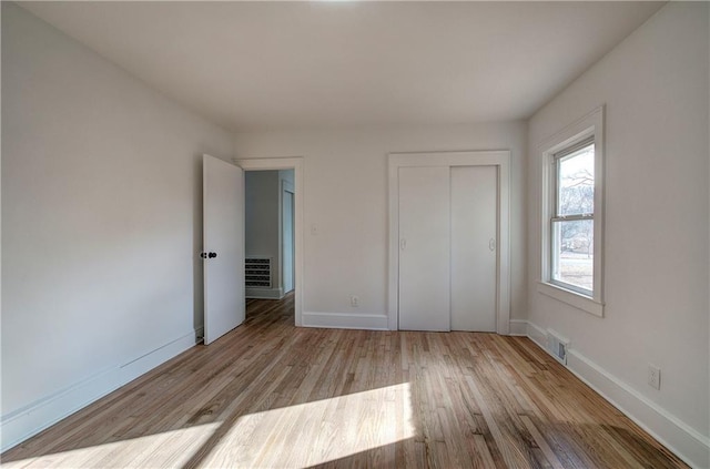 unfurnished bedroom with a closet and light hardwood / wood-style floors