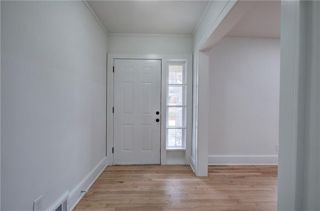 foyer with plenty of natural light, light wood-type flooring, and crown molding