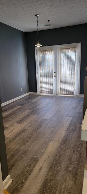 unfurnished dining area with dark hardwood / wood-style flooring, a wealth of natural light, and a textured ceiling