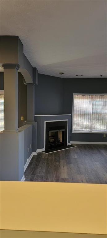 unfurnished living room with dark hardwood / wood-style flooring