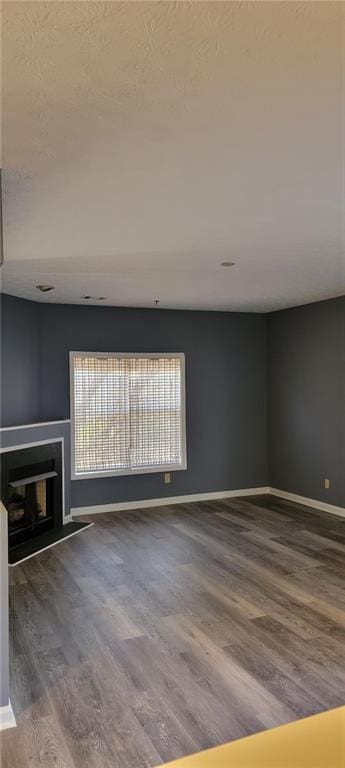 unfurnished living room featuring hardwood / wood-style floors and a textured ceiling