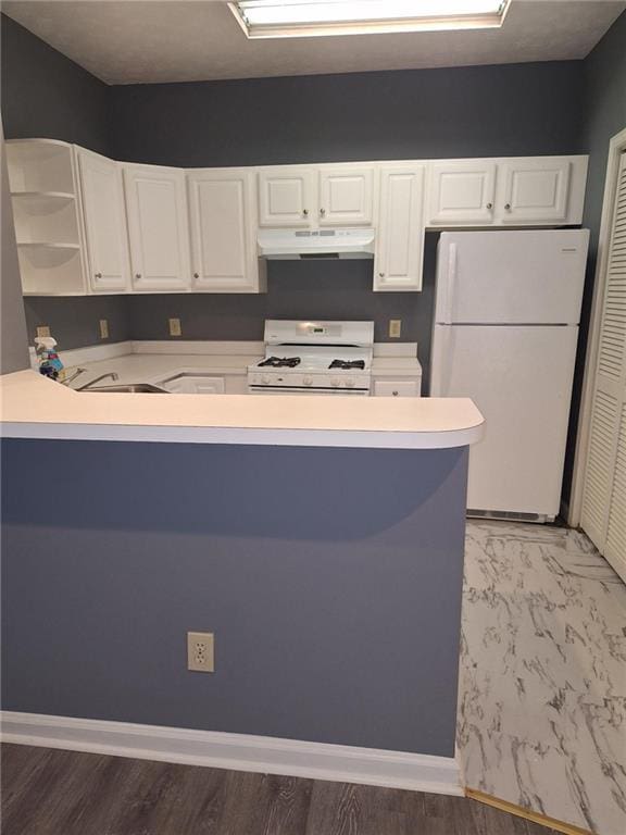 kitchen featuring white cabinetry, sink, white appliances, and kitchen peninsula