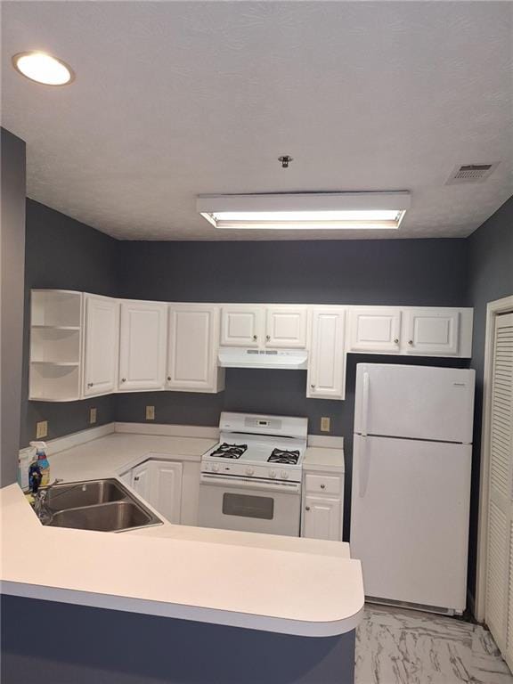 kitchen with sink, white appliances, kitchen peninsula, and white cabinets