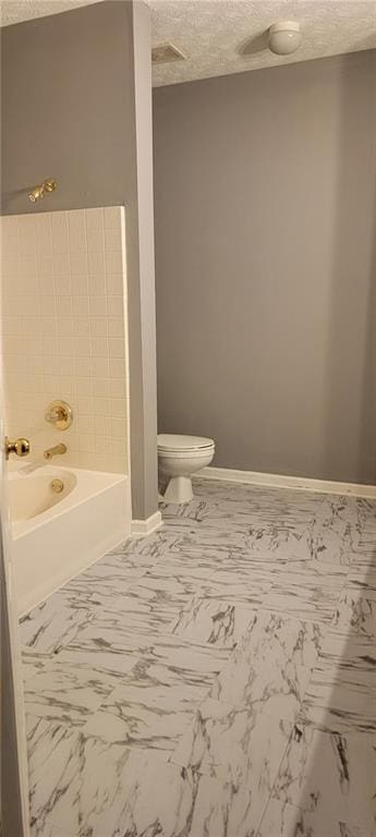 bathroom with toilet and a textured ceiling