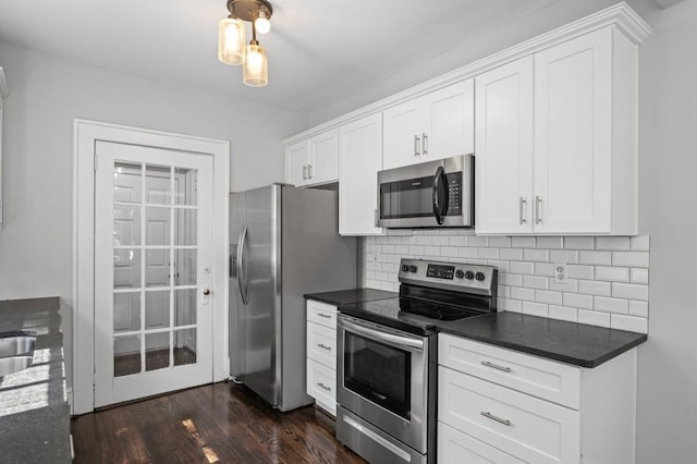 1585 Olympian Cir SW, Atlanta, GA 30310 - kitchen featuring appliances with stainless steel finishes, dark countertops, tasteful backsplash, and white cabinetry