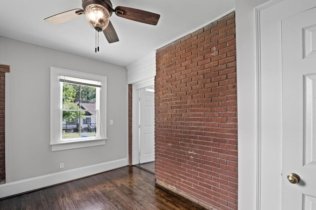 1585 Olympian Cir SW, Atlanta, GA 30310 - unfurnished bedroom featuring brick wall, dark wood-style flooring, and a ceiling fan