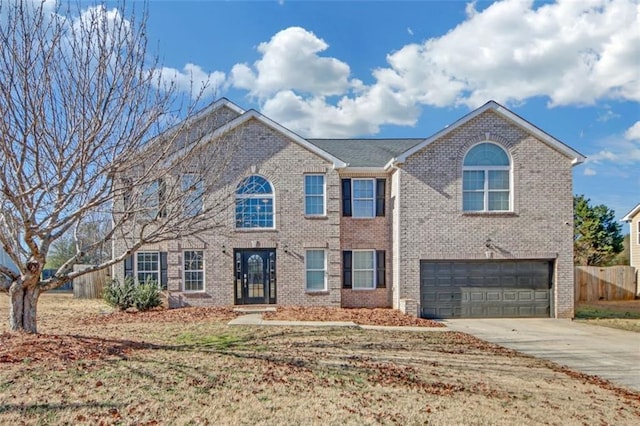 view of front of property featuring driveway, an attached garage, fence, and brick siding