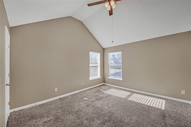 spare room with baseboards, a ceiling fan, vaulted ceiling, and carpet flooring