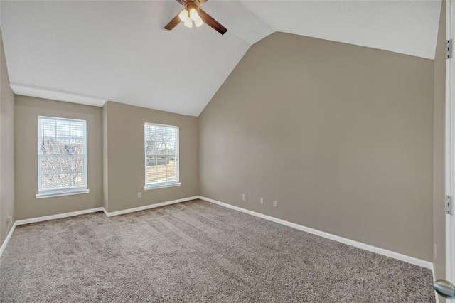 carpeted empty room with baseboards, vaulted ceiling, and a ceiling fan