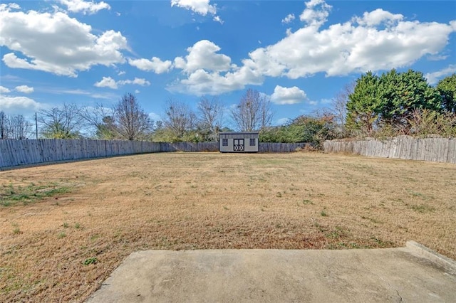 view of yard with an outbuilding, a storage shed, and a fenced backyard