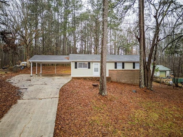 single story home featuring an attached carport, concrete driveway, and brick siding