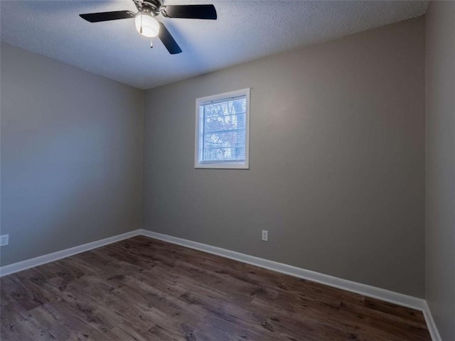 spare room featuring a textured ceiling, dark wood-style flooring, a ceiling fan, and baseboards