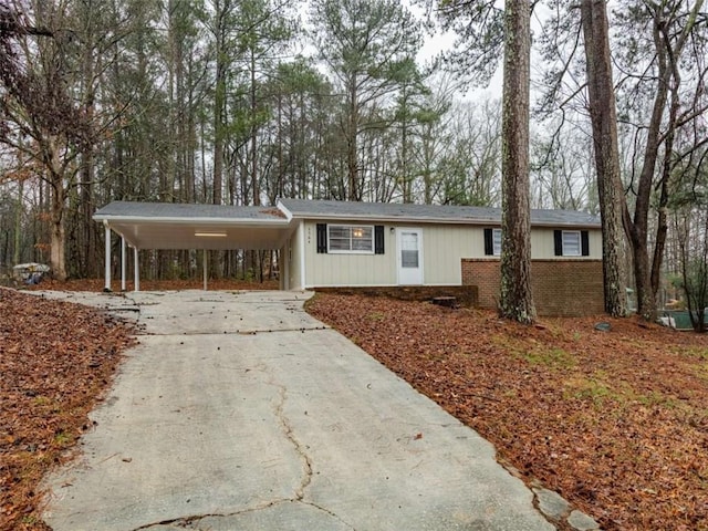 single story home with a carport, concrete driveway, and brick siding