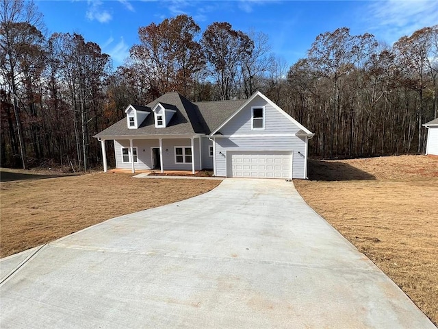 view of front of house featuring a shingled roof, a porch, a front yard, a garage, and driveway