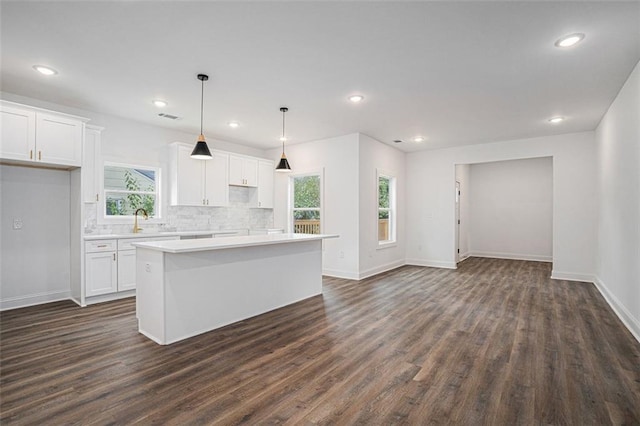 kitchen featuring pendant lighting, a kitchen island, and white cabinetry