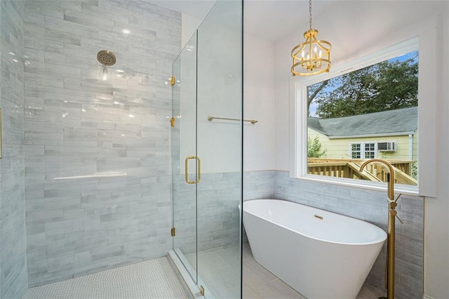 bathroom featuring a chandelier, shower with separate bathtub, tile walls, and tile patterned flooring