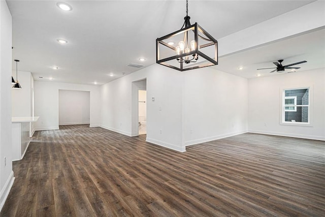 unfurnished living room featuring dark wood-type flooring and ceiling fan with notable chandelier