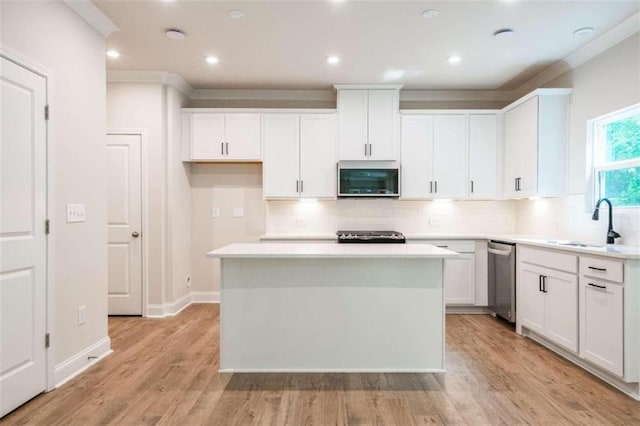 kitchen with appliances with stainless steel finishes, a center island, and white cabinets