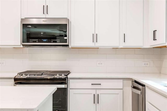 kitchen with stainless steel appliances, white cabinetry, and tasteful backsplash