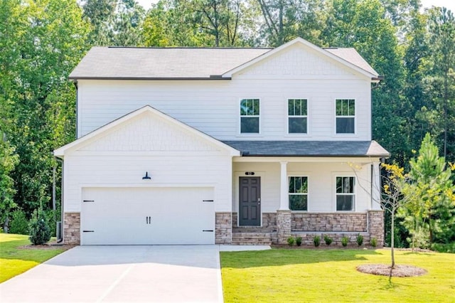view of front of property with stone siding, a front yard, and concrete driveway