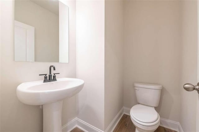 bathroom with toilet and hardwood / wood-style flooring