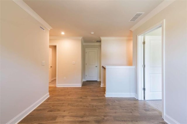 spare room featuring crown molding, wood finished floors, baseboards, and recessed lighting