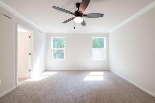 spare room featuring carpet floors, ornamental molding, plenty of natural light, and a ceiling fan