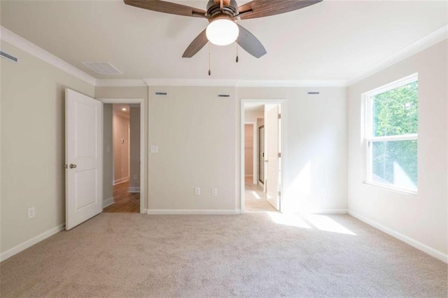 unfurnished bedroom featuring light carpet, ornamental molding, and ceiling fan