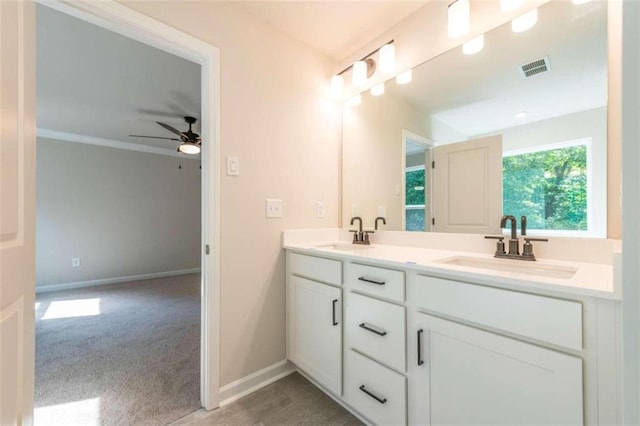 bathroom with ceiling fan, double vanity, and baseboards