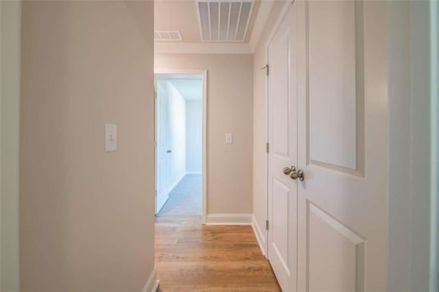 hall featuring light wood-style flooring and baseboards
