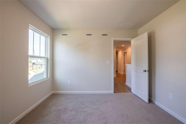unfurnished room with carpet flooring and baseboards