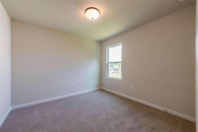 carpeted empty room with baseboards