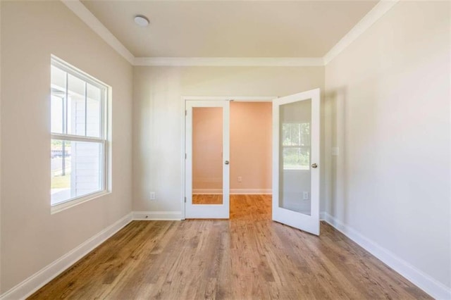 unfurnished bedroom featuring french doors, crown molding, wood finished floors, and baseboards