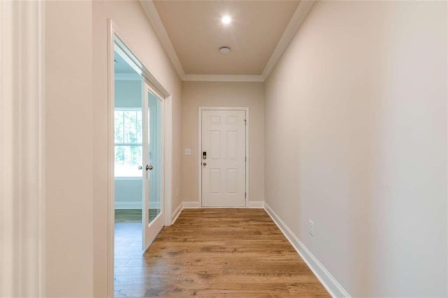 doorway featuring ornamental molding and light hardwood / wood-style flooring